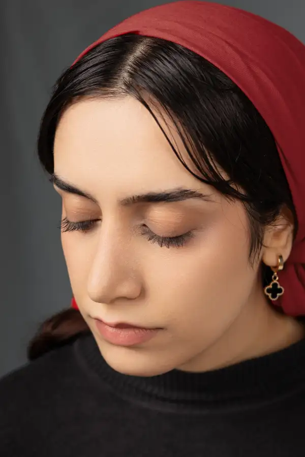 پرتره‌ی استودیویی با نگاهی رو به پایین؛ تصویری متفکرانه با نورپردازی نرم که حس آرامش و وقار درونی را القا می‌کند.